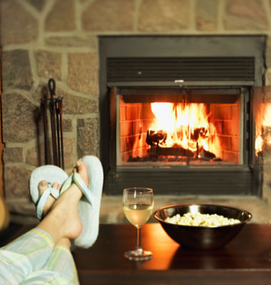 A woman sitting in front of fireplace - Mac and Son Tree Expert Offering Firewood services...